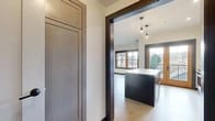 Located in Portland's NW Irving Street neighborhood, this thoughtfully designed single-floor residence blends modern aesthetics with functional living. Polished concrete-style flooring flows seamlessly throughout, anchoring a cohesive, contemporary palette of warm neutrals and dark trim accents.

The kitchen serves as the heart of the home, featuring a navy-blue island with a crisp white countertop, pendant lighting overhead, and warm taupe upper cabinetry. A classic white subway tile backsplash complements stainless steel appliances, including a gas range, dishwasher, microwave, and refrigerator. A sliding glass door with warm wood framing opens directly to a private balcony, offering outdoor views and ample natural light.

Bedrooms are well-proportioned, with large dark-trimmed windows and ceiling fans providing comfort and brightness. Built-in cabinetry with shaker-style doors and lower drawers provides generous storage in multiple rooms, reinforcing the home's efficient design.

The bathroom is finished with a dark-toned vanity topped with a white quartz surface, a tiled walk-in shower featuring large-format white tiles and chrome fixtures, and accessible grab bar hardware. Clean lines and neutral tones carry throughout, creating a calm, polished atmosphere. Dark door frames and trim tie each room together for a cohesive modern look.