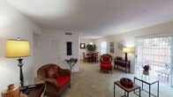 This single-floor residence offers a thoughtfully organized layout that balances comfort and functionality across multiple living spaces. The open living room is carpeted and filled with natural light from large sliding glass doors that lead to a private outdoor patio, providing a seamless indoor-outdoor connection. The room offers generous space for seating and relaxation, with clean white walls that create a bright, welcoming ambiance.

Adjacent to the living area, the dining space features a pendant light overhead and a window that brings in additional natural light, making it an inviting area for everyday meals. The kitchen is equipped with warm-toned wood cabinetry, ample counter space, a double-basin sink, a dishwasher, and a range, offering practical storage and workspace.

The two bedrooms are carpeted and well-lit by natural light through windows fitted with blinds. Each room provides a calm, restful environment with neutral wall tones. The full bathroom includes a tub-shower combination with tile surround and wood-look flooring, offering a clean and functional design.

A versatile bonus room, also carpeted and naturally lit, provides additional flexible space suitable for a home office or sitting area. Throughout the residence, carpet flooring, neutral walls, and an abundance of windows contribute to a cohesive and comfortable living environment.