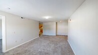 Located at 21 Henry St in Norwich, CT, this one-bedroom, one-bathroom unit offers a practical and comfortable single-floor layout. The living room is generously sized, featuring warm beige carpeting, neutral-toned walls, a textured ceiling, and a window that brings in natural light and views of the surrounding greenery. The space provides ample room for a variety of furniture arrangements.

The kitchen is well-appointed with warm oak cabinetry offering abundant storage, grey laminate countertops, and a full suite of appliances including a refrigerator, electric range, and dishwasher. Light tile flooring completes the functional and tidy cooking space.

The bedroom is a comfortable retreat, finished with plush carpeting, soft neutral walls, and a large window fitted with horizontal blinds that overlook the outdoor surroundings. A built-in closet with paneled double doors provides convenient storage.

The bathroom is notably spacious, featuring light tile flooring, crisp white walls, and a grab bar — offering both comfort and accessibility. The unit's overall design is clean and understated, with consistent neutral tones and carpet throughout the main living areas, creating a cohesive and move-in ready atmosphere.