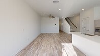 This two-story home in Union City, Georgia offers a clean, modern design spread across two well-proportioned floors. Light wood-style flooring flows throughout, complementing the bright white walls and creating a fresh, airy atmosphere. The main level features an open-concept kitchen and living area flooded with natural light from multiple windows. The kitchen is equipped with stainless steel appliances, white cabinetry, recessed lighting, and a central island with a sink — ideal for both cooking and casual dining. The living room extends generously from the kitchen, complete with a ceiling fan and a staircase leading to the upper level. An attached garage with an automatic opener provides convenient additional storage or parking. Upstairs, two bedrooms each feature ceiling fans and light-filled interiors with hardwood-style flooring. The spacious primary bedroom includes a walk-in closet with built-in shelving and a private en-suite bathroom fitted with a glass-enclosed walk-in shower. A second closet and additional bathrooms serve the rest of the home, including a compact half bath on the main floor. With three bathrooms total, multiple hallways, and dedicated closet spaces, this home balances functional layout with a clean, contemporary aesthetic throughout.