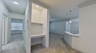 This contemporary apartment boasts a well-designed open floor plan, seamlessly connecting the living area and kitchen. The living space is bright and airy, with recessed lighting and pendant fixtures adding a touch of elegance. The kitchen features white cabinetry, stainless steel appliances, and a subway tile backsplash. Bedrooms are generously sized with large windows and ceiling fans. The bathroom offers a modern aesthetic with a tub-shower combination and sleek vanity. Neutral tones and carpeting in main areas create a cohesive look, while the kitchen and bathroom feature durable wood-look flooring. Ample storage is provided through built-in shelving and walk-in closets.