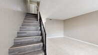 Located at 2130 S Palmetto Ave in South Daytona, FL, this two-story, 2-bedroom, 2-bathroom home offers a practical and well-organized layout spread across two floors. The main level features a bright living room with large tile flooring and a front-facing window that draws in natural light, alongside a functional kitchen outfitted with white cabinetry, dark marble-style countertops, tile flooring, and black appliances including a full-size refrigerator and electric range. A staircase with wood-look treads and a black iron railing connects the two levels, adding a clean visual element to the interior. The upper floor houses both bedrooms, each featuring light gray wood-look flooring, neutral walls, and textured ceilings. The generously sized primary bedroom includes a closet for storage. The second bedroom also offers a closet with louvered bifold doors and a window for natural light. Two bathrooms serve the home, one of which includes a single-sink vanity and a tub-shower combination with tile surround. Throughout the home, neutral tones and consistent finishes create a cohesive and functional living environment suited for comfortable everyday living in South Daytona.