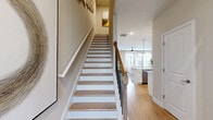 Located at 135 Jodeco Road in McDonough, GA, this two-story home offers a thoughtfully designed layout spread across two floors. The main level features an open-concept kitchen and living area highlighted by white shaker cabinetry, granite countertops, a subway tile backsplash, and stainless steel appliances. Light hardwood flooring flows throughout, enhancing the bright, airy atmosphere. A casual dining area benefits from natural light through a rear door, while a convenient pantry and a half bath round out the lower level. An attached garage with an automatic opener provides additional functionality.

Upstairs, the landing opens to a well-lit hallway connecting the home's key spaces. The spacious primary bedroom features natural light from multiple windows, ceiling fan, and a generous walk-in closet. A dedicated office provides an ideal workspace with ample shelving and natural light. The upper floor also includes a full laundry room equipped with a front-load washer and dryer set with wire shelving above. Four bathrooms in total serve the home's occupants with ease. Throughout, the neutral warm-toned palette, recessed lighting, and consistent hardwood flooring create a cohesive, modern aesthetic suited for comfortable everyday living.