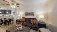 Located at 1860 Brevard Rd in Arden, NC, this two-floor residence offers a thoughtfully designed layout with functional living spaces throughout. The kitchen is a standout feature, outfitted with dark espresso cabinetry, stainless steel appliances including a refrigerator with ice maker, electric range, and over-the-range microwave, all complemented by light quartz countertops and a peninsula with bar seating. Pendant lighting and light wood-style flooring give the kitchen a clean, modern feel, with direct access to an exterior door. The living room is bright and welcoming, featuring light hardwood-style flooring, a ceiling fan, and a natural color palette that creates a relaxed atmosphere. The bedrooms are carpeted and include ceiling fans, natural light from blinds-covered windows, and closet access — one bedroom is spacious enough to accommodate a king-sized bed, while another comfortably fits two twin beds. The bathrooms are cleanly finished, with one full bath featuring a shower/tub combination, dark vanity, and light tile flooring. A second bathroom presents a minimalist, crisp white design. Throughout the space, neutral tones and practical finishes contribute to a comfortable and livable environment.