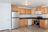 Located at 840 S Main St in Cedar City, Utah, this well-appointed one-bedroom, one-bathroom unit offers a thoughtfully organized single-floor layout. Light hardwood flooring runs throughout, complementing the clean white walls and textured ceilings to create a bright, cohesive aesthetic.

The combined kitchen and living area forms the heart of the space. The kitchen is outfitted with warm-toned natural wood cabinetry extending to the ceiling for generous storage, dark granite-style countertops, and a full suite of stainless steel appliances including a refrigerator, electric range, built-in microwave, and dishwasher. A double basin sink is centrally positioned along the counter.

The living area is open and versatile, featuring a wall-mounted HVAC unit and a window that brings in natural light. The bedroom is a comfortable, well-proportioned room with its own window offering views of the surrounding mountain landscape, allowing abundant natural light to fill the space. A dedicated closet provides practical storage.

The bathroom includes a full tub and shower combination, a toilet, and a vanity with matching wood cabinetry and granite-style countertop. Every room reflects a clean, move-in ready condition, making this unit a practical and inviting option in Cedar City.