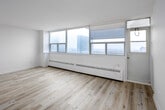 Located on the penthouse level at 45 Dunfield Ave in Toronto's vibrant Midtown neighbourhood, this one-bedroom, one-bathroom unit offers a well-appointed and efficiently designed layout finished with light-toned hardwood flooring throughout. A welcoming hallway with intercom access leads into the main living areas, setting a clean, bright tone from the moment you enter.

The living area is a standout space, featuring expansive floor-to-ceiling windows that span the full width of the room, flooding it with natural light and framing sweeping panoramic views of the Toronto skyline. Baseboard heating runs along the window wall, and the crisp white walls enhance the airy, open feel.

The kitchen is thoughtfully laid out with ample white cabinetry above and below a continuous countertop, complemented by a subway tile backsplash, stainless steel stove, and a double sink — offering practical functionality in a compact footprint.

The bedroom is a comfortable, well-proportioned space with its own window overlooking city rooftops, continuing the bright aesthetic. A set of double closet doors provides generous built-in storage.

The bathroom is clean and functional, featuring a full soaker tub with shower, a white vanity with storage, and neutral tile flooring, completing this polished penthouse unit.
