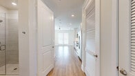 Located at 930 Ridgeview Dr in Allen, TX, this efficiently designed single-floor unit offers a bright, contemporary living experience. The open-concept layout seamlessly connects the kitchen and living area, maximizing the sense of space. Light wood-tone luxury vinyl plank flooring runs throughout, complementing the clean, neutral color palette of white and soft gray tones.

The kitchen is a standout feature, outfitted with gray shaker-style cabinetry extending to the ceiling for generous storage, granite countertops, a classic white subway tile backsplash, and a full suite of stainless steel Whirlpool appliances including a French door refrigerator, electric range, over-the-range microwave, and dishwasher. Recessed lighting illuminates the space efficiently.

The living area benefits from abundant natural light, with large windows and a set of glass French doors that open to the exterior, giving the space an airy, open feel. A ceiling fan adds comfort to the living zone.

The bathroom is clean and modern, featuring wood-look tile flooring, a frameless glass walk-in shower with large-format neutral tile surround, and sleek chrome fixtures. The overall design of this unit is polished, functional, and move-in ready, ideal for those seeking a well-appointed, low-maintenance living space in Allen, TX.