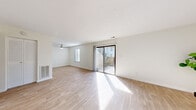 This single-floor, 2-bedroom residence offers a thoughtfully designed layout that maximizes its compact footprint. The bright and airy living room serves as the heart of the home, featuring light hardwood-style flooring, a ceiling fan, and large sliding glass doors that open to an outdoor patio, flooding the space with natural light. The clean white walls and neutral palette create a fresh, open ambiance throughout.

The galley-style kitchen is efficiently designed with white shaker cabinets, granite countertops, a subway tile backsplash, stainless steel appliances including a gas range and refrigerator, and a undermount sink — offering both style and practicality.

Both bedrooms are carpeted for comfort and feature ample closet space, including a built-in closet rod in the primary bedroom. The primary bedroom is generously sized, while the second bedroom benefits from a window that allows natural light to filter in. Hallways connect the rooms seamlessly, leading from the entrance through the main living areas.

Overall, the space presents a clean, move-in-ready environment with consistent neutral tones, practical finishes, and a functional flow that makes efficient use of every square foot.