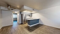 Located at 6434 E Cave Creek Rd in Cave Creek, Arizona, this single-story, one-bedroom, one-bathroom residence offers a thoughtfully designed layout with modern finishes throughout. Wood-look plank flooring runs consistently across all rooms, lending a cohesive and contemporary feel to the entire space.

The kitchen is a standout feature, equipped with gray cabinetry, stainless steel appliances including a full-size refrigerator, a built-in cooktop on the peninsula, and light quartz countertops. Recessed lighting illuminates the kitchen's tray ceiling, creating a bright and functional cooking environment. The peninsula provides additional counter space and serves as a natural divider between the kitchen and the open living area.

The bedroom is a comfortable, well-proportioned room featuring a large window fitted with vertical blinds that allow natural light while maintaining privacy. A double sliding-door closet offers generous built-in storage with a dedicated hanging rod.

The bathroom is clean and efficiently laid out, featuring a tub-shower combination, a toilet, and a vanity with gray cabinetry, a white countertop, and a round mirror. The wood-look flooring extends into this room as well, maintaining design consistency. Overall, the space presents a modern, move-in-ready aesthetic suited for comfortable everyday living.
