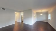 This single-floor residence offers a clean, modern aesthetic throughout, highlighted by a neutral gray-and-white color palette and consistent finishes across every room. The open-concept living and dining area features rich, dark hardwood-style flooring and multiple windows that invite natural light, creating a bright and welcoming atmosphere. A pendant light fixture adds a refined touch to the dining space.

The kitchen is well-equipped and thoughtfully designed, featuring white shaker-style cabinetry with ample upper and lower storage, white countertops, a stainless steel refrigerator, dishwasher, and range, as well as a central island that provides additional prep and counter space. A pass-through window connects the kitchen to an adjoining area, enhancing the open feel.

The bedrooms are finished with plush neutral carpeting, offer generous proportions, and include closets with bifold doors for convenient storage. Each room is served by consistent HVAC ventilation and shares the home's soft, understated color scheme.

The bathrooms are finished with striking marble-style tile flooring, dark-toned vanities with white countertops, large mirrors, and clean white fixtures, contributing to a polished and contemporary feel. Natural light filters into one bathroom through a gridded window, adding to the overall brightness of the space.