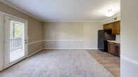Located at 2160 N Thompson Ln in Murfreesboro, TN, this one-bedroom, one-bathroom unit offers a well-organized single-floor layout designed for comfortable everyday living. The open-concept living and dining area is generously proportioned, featuring warm neutral-toned walls, plush wall-to-wall carpeting, and elegant crown molding with a chair rail accent that lends a classic touch to the space. The kitchen flows seamlessly from the living area and is equipped with rich, dark wood cabinetry, black appliances including a refrigerator, dishwasher, and range with overhead ventilation, as well as wood-look flooring that provides a clean contrast to the carpeted living space. The bedroom is a comfortable retreat, finished with soft carpeting, a ceiling fan with light fixture, and a window with blinds that allows natural light to filter in. A dedicated closet provides ample storage. The bathroom features a full tub-shower combination, wood-look flooring, and a toilet, all within a clean, functional layout. A hallway connects the rooms efficiently, completing this thoughtfully arranged and move-in-ready unit.