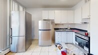 Located at 55 Brownlow Ave in Toronto's desirable Davisville Village neighbourhood, this one-bedroom, one-bathroom unit offers a practical and well-organized layout across a single floor. The space is accessed through a hallway that connects each room efficiently.

The kitchen is equipped with white cabinetry, dark countertops, and a tiled backsplash, providing ample storage and prep space. Light tile flooring adds brightness to the area, which also features a full-size stainless steel refrigerator and stove. Large sliding glass doors open directly from the kitchen area onto a balcony, filling the space with natural light and offering pleasant views of the surrounding neighbourhood, including mature trees and green space.

The bedroom features warm-toned parquet flooring, lending a classic character to the room. Neutral walls keep the space feeling clean and adaptable to various furnishing styles.

The bathroom includes a full bathtub with an overhead shower, finished with light beige ceramic wall tiles that create a clean, understated aesthetic.

The building is situated adjacent to a generous green lawn area, contributing to a pleasant outdoor environment. This unit is well-suited for those seeking a functional home in a central Toronto location with easy access to local amenities.