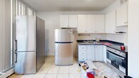 Located at 55 Brownlow Ave in Toronto's desirable Davisville Village neighbourhood, this one-bedroom, one-bathroom unit offers a practical and well-organized layout across a single floor. The space is accessed through a hallway that connects each room efficiently.

The kitchen is equipped with white cabinetry, dark countertops, and a tiled backsplash, providing ample storage and prep space. Light tile flooring adds brightness to the area, which also features a full-size stainless steel refrigerator and stove. Large sliding glass doors open directly from the kitchen area onto a balcony, filling the space with natural light and offering pleasant views of the surrounding neighbourhood, including mature trees and green space.

The bedroom features warm-toned parquet flooring, lending a classic character to the room. Neutral walls keep the space feeling clean and adaptable to various furnishing styles.

The bathroom includes a full bathtub with an overhead shower, finished with light beige ceramic wall tiles that create a clean, understated aesthetic.

The building is situated adjacent to a generous green lawn area, contributing to a pleasant outdoor environment. This unit is well-suited for those seeking a functional home in a central Toronto location with easy access to local amenities.
