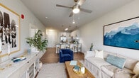 Located at 3600 Courtney Dr in Panama City, Florida, this single-story residence showcases a clean, contemporary design with a cohesive neutral color palette and wood-look flooring that flows throughout the main living areas. The open-concept layout connects the kitchen, dining, and living spaces seamlessly, creating a bright and airy atmosphere enhanced by natural light from well-placed windows.

The kitchen is a standout feature, offering white shaker-style cabinetry, dark countertops, a subway tile backsplash, and a full suite of stainless steel appliances including a refrigerator, range, microwave, and dishwasher. A peninsula with seating for multiple bar stools serves as both a prep space and casual dining area, illuminated by a trio of brushed nickel pendant lights.

The living area provides a generous, comfortable space anchored by a ceiling fan and accented by coastal-inspired décor. Bedrooms are carpeted for comfort, each featuring ceiling fans, ample natural light, and access to closet space. The primary bedroom connects to an en-suite bathroom, while an additional bathroom features white subway tile surrounding a tub-shower combination, dark countertops, and wood-look flooring — consistent with the home's modern aesthetic throughout.