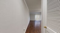 This single-floor, 1-bedroom, 1-bathroom unit offers a practical and comfortable layout across a compact yet efficiently organized floor plan. Rich, dark hardwood-style flooring flows consistently throughout the space, complemented by crisp white baseboards and elegant crown molding that add a polished finish to every room.

The combined dining and living area serves as the central hub of the unit, offering an open, airy feel enhanced by a ceiling fan with integrated lighting and a large sliding glass door dressed with vertical blinds that allow for generous natural light. A pass-through counter connects the living area to the galley-style kitchen, which features white cabinetry, light granite-style countertops, a double basin sink, a white electric range, and a dishwasher. A louvered door within the kitchen provides additional storage access.

The bedroom is a well-sized private retreat, equipped with a ceiling fan, a window with views to the outdoors, and two closeted spaces — one of which leads to a dedicated closet room. A hallway connects the bedroom to the bathroom, completing the functional layout. The unit's neutral color palette and consistent flooring create a cohesive, move-in-ready environment throughout.