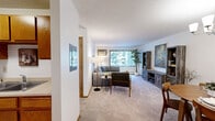 Located at 3415 Federal Dr in Eagan, MN, this one-bedroom, one-bathroom unit offers a thoughtfully arranged single-floor layout that maximizes every square foot. The open living and dining area serves as the heart of the home, with soft carpeting underfoot, a large window that draws in natural light and frames views of surrounding greenery, and a wall-mounted air conditioning unit for year-round comfort. The dining space features a stylish chandelier and full mirrored closet doors that visually expand the room. The galley-style kitchen is efficiently designed with warm oak cabinetry lining both walls, light countertops, tile flooring, and white appliances including a range, refrigerator, and dishwasher. The bedroom is a comfortable retreat, offering carpet flooring, a large sliding wood-panel closet, a window with vertical blinds allowing natural light, and a textured ceiling. Three closets throughout the unit provide generous storage. The full bathroom includes an oak vanity with a wide mirror, tile flooring, and a shower-tub combo. With a clean, functional layout and classic finishes, this unit delivers practical and comfortable living in a convenient Eagan location.