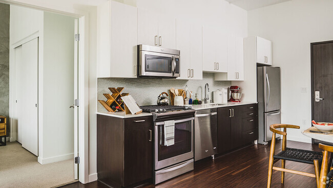 Well appointed kitchen featuring espresso lower cabinetry and white upper cabinetry - Blossom Plaza