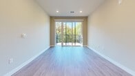 Located in Madison, WI, this well-appointed 4-bedroom, 2-bathroom single-floor home offers a thoughtfully designed layout with modern finishes throughout. The open-concept kitchen and living area serves as the heart of the home, featuring light wood cabinetry, stainless steel appliances including a refrigerator, range, and dishwasher, white countertops, and light wood-style flooring that extends seamlessly through the shared spaces. The living area opens to a private balcony via large sliding glass doors, flooding the space with natural light and offering pleasant tree-lined views. The primary bedroom is generously sized and includes access to a dedicated closet outfitted with wire shelving and hanging rods, along with plush carpeting underfoot. The remaining three bedrooms are each carpeted and feature ceiling fans, windows with leafy outdoor views, and clean neutral walls. The bathrooms are finished with warm wood-toned cabinetry, backlit mirrors, and light flooring, with one bathroom featuring a full soaking tub and shower combo. A cohesive neutral color palette, recessed lighting, and clean architectural lines give the entire home a fresh, contemporary feel throughout.