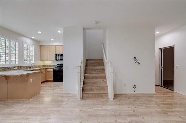 Living room, kitchen and stairs to second floor - 10522 Maple Ln