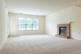 Located at 3101 Stratton Way in Madison, Wisconsin, this single-floor, 2-bedroom, 2-bathroom home offers a well-organized layout designed for comfortable everyday living. The open-concept kitchen and living area serves as the heart of the home, featuring white cabinetry, stainless steel appliances, a peninsula with counter seating, and light hardwood-style flooring that transitions into plush carpeting in the living space. The spacious living room is highlighted by a classic brick fireplace with a raised hearth and track lighting overhead, creating a warm and inviting atmosphere. The generously sized primary bedroom includes multiple windows that invite abundant natural light and a ceiling fan, while a dedicated closet provides ample storage. The second bedroom is similarly carpeted and includes its own closet access. The primary bathroom offers dual sinks with an extended vanity, hardwood-style flooring, and a separate tub area, while the second bathroom includes a full tub/shower combo with clean, bright finishes. Four closets throughout the home ensure excellent storage. A private patio overlooks a landscaped community setting with mature trees. In-unit laundry adds everyday convenience to this thoughtfully designed home.