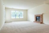 Located at 3101 Stratton Way in Madison, Wisconsin, this single-floor, 2-bedroom, 2-bathroom home offers a well-organized layout designed for comfortable everyday living. The open-concept kitchen and living area serves as the heart of the home, featuring white cabinetry, stainless steel appliances, a peninsula with counter seating, and light hardwood-style flooring that transitions into plush carpeting in the living space. The spacious living room is highlighted by a classic brick fireplace with a raised hearth and track lighting overhead, creating a warm and inviting atmosphere. The generously sized primary bedroom includes multiple windows that invite abundant natural light and a ceiling fan, while a dedicated closet provides ample storage. The second bedroom is similarly carpeted and includes its own closet access. The primary bathroom offers dual sinks with an extended vanity, hardwood-style flooring, and a separate tub area, while the second bathroom includes a full tub/shower combo with clean, bright finishes. Four closets throughout the home ensure excellent storage. A private patio overlooks a landscaped community setting with mature trees. In-unit laundry adds everyday convenience to this thoughtfully designed home.