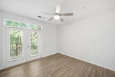 This 730-square-foot, one-bedroom, one-bathroom apartment at 400 Evolve Drive in Garner, NC, offers a well-designed single-floor layout with contemporary finishes throughout. The open-concept kitchen and living area serves as the heart of the home, featuring warm hardwood-style flooring, crisp white cabinetry, granite countertops, stainless steel appliances, and a central island with pendant lighting overhead — ideal for both cooking and entertaining. The living room is bright and airy, with a ceiling fan and French doors topped by a transom window that flood the space with natural light and provide direct access to a private balcony. The 160-square-foot bedroom is carpeted for comfort and includes a ceiling fan, ample natural light from a large window with outdoor views, and access to a dedicated closet. The bathroom features tile flooring, a granite-topped vanity with white cabinetry, and a clean, functional layout. Throughout the unit, neutral tones, white panel doors, and consistent finishes contribute to a cohesive and modern ambiance. The apartment also includes a closet for additional storage, rounding out a practical and attractive living space.