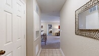 Located in Orlando, FL, this single-floor, two-bedroom, two-bathroom residence offers a well-organized layout designed for comfortable everyday living. A tiled entrance hallway welcomes you in, leading to the open-concept living, dining, and kitchen area at the heart of the home. The living room features plush carpeting, a ceiling fan, and a large window that draws in natural light and outdoor views. Adjacent to it, the dining area accommodates a full dining set and sits next to a convenient pantry with built-in shelving. The kitchen is equipped with wood-toned cabinetry, a gas range, a refrigerator, a double sink, and hardwood-style flooring, along with a breakfast bar with barstool seating. The primary bedroom offers carpet flooring, a ceiling fan, a generous walk-in closet with wire shelving, and a large window overlooking greenery outside. The second bedroom also features carpet, a ceiling fan, and direct access to a bathroom. Both bathrooms include a shower-tub combination with white tile surround. A dedicated in-unit laundry room with side-by-side washer and dryer and overhead shelving adds everyday practicality. Three closets throughout provide ample storage across the entire residence.