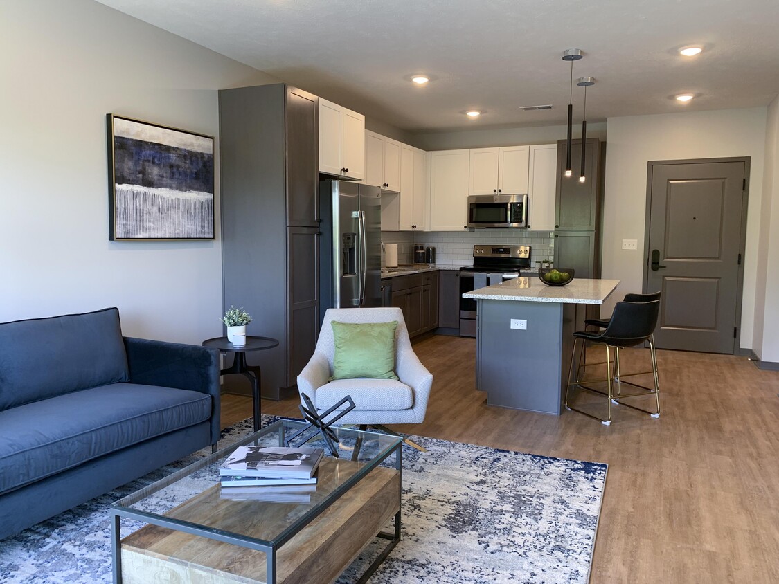 Open-concept living spaces combine modern kitchens with cozy lounge areas, creating the perfect home for relaxation and connection. - Haven at Uptown