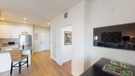 This single-floor residence offers a thoughtfully designed layout that balances comfort and functionality throughout. Warm hardwood-style flooring flows seamlessly across the main living areas, creating a cohesive and inviting atmosphere from entry to living room.

The open-concept kitchen is outfitted with white cabinetry, a gray countertop peninsula with an integrated sink, and stainless steel appliances including a dishwasher and full-size refrigerator. The kitchen connects naturally to the combined dining and living area, making the space ideal for everyday living and entertaining. The living room is generously proportioned, anchored by large sliding glass doors that open to a private balcony, filling the space with natural light and outdoor views.

The bedrooms are well-sized and versatile. The primary bedroom benefits from multiple windows that bring in ample natural light, while a secondary bedroom features a neutral accent wall and built-in floating shelves, offering a functional setup for a bedroom or home office.

Both bathrooms are finished in neutral tones with tile flooring, white vanity cabinetry, gray countertops, and shower-tub combinations. A hallway with recessed lighting and interior doors connects the various rooms, contributing to the home's organized and efficient flow throughout.