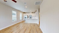 Located in Conroe, TX, this single-story, one-bedroom, one-bathroom home offers a well-designed open-concept layout finished with warm wood-look luxury vinyl plank flooring throughout. Neutral warm-gray walls and abundant natural light from multiple windows create a clean, inviting atmosphere across the entire floor plan.

The living area is bright and open, featuring a ceiling fan and a glass-panel door that fills the room with natural light. It flows seamlessly into the kitchen, which serves as the heart of the home. The kitchen is outfitted with white shaker cabinets, marble-look quartz countertops, a peninsula with an undermount sink and matte black faucet, and a full suite of stainless steel appliances including a French door refrigerator, range, and microwave.

The bedroom is a comfortable, well-lit retreat with a ceiling fan and two windows offering views of the surrounding neighborhood. It connects to a generously sized walk-in closet with built-in shelving and hanging rods on multiple walls for ample storage.

The bathroom features a white vanity with quartz countertops, matte black hardware, a large mirror, and a glass-enclosed walk-in shower with white tile surround and a black-framed door. A dedicated laundry area completes the practical layout of this thoughtfully designed home.