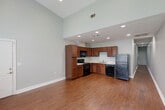 Located on Gayosa Street in Baton Rouge, Louisiana, this single-story, 2-bedroom, 2-bathroom residence offers a well-designed layout centered around an open-concept living and kitchen area. The space is immediately striking thanks to its soaring vaulted ceilings, which lend an airy, expansive feel throughout the main living zone. Warm hardwood-style flooring runs continuously through the living, kitchen, and bedroom areas, creating a cohesive and inviting aesthetic.

The kitchen is thoughtfully appointed with rich medium-toned wood cabinetry, ample counter space, and a full suite of black appliances, including a refrigerator, range, built-in microwave, and dishwasher. Recessed lighting illuminates both the kitchen and living areas effectively.

Both bedrooms feature the same hardwood-style flooring, neutral gray walls, and windows with blinds that allow natural light while maintaining privacy. One bedroom includes a ceiling fan, adding both comfort and functionality. The bedrooms offer a calm, understated atmosphere suitable for rest or a home office setup.

The two bathrooms are finished with light tile flooring, warm wood vanities with white countertops, and tub-shower combinations, providing a clean and practical design. Overall, the residence presents a consistent, neutral palette throughout, making it a versatile and move-in-ready space.