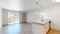Located at 360 24th St NW in Winter Haven, Florida, this single-floor unit offers a clean, modern living experience with a cohesive design aesthetic throughout. The open-concept layout connects the living area and kitchen seamlessly, creating a bright and airy atmosphere enhanced by light wood-style flooring that runs throughout the space.

The kitchen is a standout feature, equipped with stainless steel appliances including a refrigerator, range, microwave, and dishwasher. A peninsula with granite countertops and an undermount sink serves as both a functional workspace and casual dining area, illuminated by a set of elegant pendant lights overhead. White cabinetry and a classic subway tile backsplash complete the kitchen's polished look.

The living area is generously proportioned and opens directly to an outdoor area through a full-width sliding glass door with vertical blinds, allowing for an abundance of natural light and easy outdoor access. The bedroom is a comfortable, well-lit room featuring a ceiling fan with light fixture and a window that brings in additional natural light.

The bathroom is finished with tasteful attention to detail, featuring a granite-topped vanity, white subway tile surrounding the tub and shower combination, and brushed nickel fixtures. The overall design of the space is fresh, neutral, and move-in ready, making it a functional and attractive home in central Florida.