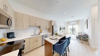Located at 475 SW 27th Ave in Fort Lauderdale, FL, this well-designed 2-bedroom, 2-bathroom residence offers a thoughtfully organized single-level layout with modern finishes throughout. The open-concept kitchen, dining, and living area forms the heart of the home, featuring light wood cabinetry, stainless steel appliances, a white quartz countertop island with bar seating, and a white subway tile backsplash — all set atop light-toned wood-style flooring that flows seamlessly through the space. The living area is bright and airy, enhanced by large sliding glass doors that lead to a private balcony overlooking a lush, palm-lined Fort Lauderdale streetscape. Both bedrooms are well-proportioned with large windows that invite natural light and treetop views. The bathrooms are finished in neutral tones, with the primary bath featuring a glass-enclosed walk-in shower and light wood vanity. A dedicated in-unit laundry room with a full-size washer and dryer adds everyday convenience. Additional highlights include a utility room, closet storage, and a clean, contemporary aesthetic defined by crisp white walls and modern fixtures throughout.