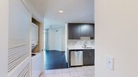 This contemporary 880 square foot apartment offers a perfect blend of style and functionality. The space features two bedrooms, including a generously sized primary bedroom of 190 square feet, and two full bathrooms. Upon entering, you're greeted by rich, dark hardwood floors that flow throughout the living areas and bedrooms, creating a cohesive and elegant atmosphere.

The living room is bathed in natural light, thanks to large windows that offer stunning views of the surrounding cityscape. These windows not only provide ample illumination but also create a sense of openness and connection to the urban environment. The kitchen is a highlight, boasting sleek dark wood cabinetry, stainless steel appliances, and a sophisticated marble backsplash. It's equipped with modern amenities, including a built-in microwave and a spacious refrigerator.

Both bathrooms are well-appointed, featuring clean lines and neutral tones. They include modern fixtures, tiled flooring, and ample storage space. The bedrooms, like the living areas, benefit from large windows that flood the spaces with natural light, enhancing the sense of spaciousness. The apartment's layout is efficient, maximizing the use of space while maintaining a comfortable and open feel. Overall, this apartment combines modern design with practical living, perfect for those seeking a contemporary urban lifestyle.