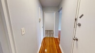 Located at Union Ave in Irvington, NJ, this 2-bedroom, 1-bathroom unit offers a well-organized single-floor layout designed for comfortable everyday living. Warm, polished hardwood floors run throughout the living areas, bedrooms, and hallway, lending a consistent and inviting character to the space. The light gray walls complement the natural wood tones, creating a clean, neutral aesthetic throughout.

The combined dining and kitchen area is a functional highlight, featuring gray shaker-style cabinetry extending to the ceiling for ample storage, granite-look countertops, a mosaic tile backsplash, and black stainless appliances including a gas range and full-size refrigerator. A window brings in natural light, making the kitchen feel open and bright.

Both bedrooms are well-proportioned, with the spacious primary bedroom offering generous room for furnishings. Each bedroom benefits from hardwood flooring, natural light through large windows, and access to one of the three closets distributed throughout the unit. The hallway connects the rooms efficiently, maintaining a smooth flow through the floor plan.

The bathroom is neatly appointed with marble-style tile surrounding the tub and shower, a white vanity with brushed nickel fixtures, a medicine cabinet mirror, and tile flooring. Overall, the unit presents a clean, updated living environment with practical storage and a cohesive design.