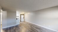 Located at 3330 West Greenway Road in Phoenix, Arizona, this one-bedroom, two-bathroom residence offers a well-planned single-floor layout designed for efficient, comfortable living. The open living area greets you at entry with a large window that fills the space with natural light, complemented by durable wood-look plank flooring and neutral gray walls beneath a textured ceiling. The kitchen is positioned adjacent to the living space and features white cabinetry, light quartz-style countertops, a stainless steel sink, and a suite of black appliances including a refrigerator, dishwasher, and electric range with overhead ventilation. A dedicated in-unit laundry closet with a stacked washer and dryer adds practical convenience. The bedroom is a comfortable retreat finished with plush carpeting, a textured ceiling, and a window with outdoor views. Two bathrooms serve the unit — one featuring a spacious vanity with a wide mirror, white cabinetry, and quartz-style countertop, the other with a full tub-shower combination. A hallway and closet complete the thoughtfully organized floor plan. Clean finishes, consistent neutral tones, and functional amenities define the overall ambiance of this Phoenix residence.