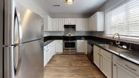 Located at 3637 Pleasantdale Rd in Atlanta, GA, this single-floor unit offers a well-designed layout with a cohesive blend of modern finishes throughout. The open living area is anchored by rich, dark wood-look flooring and neutral gray walls, creating a clean and versatile aesthetic. Ceiling fans are installed in the main living spaces, enhancing comfort and airflow. French doors in one living area invite natural light and provide outdoor access, adding a bright, airy feel to the space.

The kitchen is a functional highlight, featuring crisp white cabinetry, dark granite countertops, and a full suite of stainless steel appliances including a refrigerator, electric range, and dishwasher. Wood-look flooring continues seamlessly from the living area into the kitchen.

The bedrooms offer plush carpeting for added comfort and are served by generous windows fitted with blinds that allow for natural light control. Ceiling fans in the bedrooms contribute to a comfortable environment year-round.

Both bathrooms are finished consistently with dark granite-topped vanities, white cabinetry, wood-look flooring, and tiled tub/shower combinations with chrome fixtures. The clean, neutral palette throughout the entire unit provides a move-in ready canvas suitable for a variety of furnishing styles.