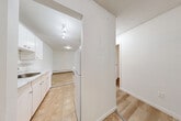 This 2-bedroom, 1-bathroom unit in Surrey, BC offers a practical and well-laid-out single-floor living space. The living room is the heart of the unit, featuring light hardwood flooring, baseboard heating, a textured ceiling, and a large sliding glass patio door that fills the room with natural light and provides views of the surrounding greenery. The kitchen is positioned adjacent to the living area and features white cabinetry, a built-in sink, tile flooring, and track lighting overhead, offering a clean and functional workspace. Both bedrooms are comfortably sized, with warm-toned hardwood flooring, textured ceilings, natural light from windows, and built-in closets with bifold doors for convenient storage. The primary bedroom is a generous size, providing ample space for furnishings. The bathroom is finished with tile flooring, a white vanity with under-cabinet storage, a large mirror, and a tiled shower surround, offering a tidy and efficient layout. Throughout the unit, a neutral white color palette and consistent flooring create a cohesive and clean aesthetic, making the space feel open and easy to personalize.