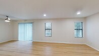 This updated single-floor residence in Memphis, Tennessee offers a well-designed layout across two bedrooms and two full bathrooms. Light wood laminate flooring runs consistently throughout the entire unit, creating a cohesive and clean aesthetic from room to room.

The living area is generously sized, featuring multiple windows with horizontal blinds, a sliding glass door with vertical blinds that invites natural light, and recessed lighting overhead. An adjacent dining area connects seamlessly to the kitchen via a pass-through counter with a breakfast bar overhang and a ceiling fan above.

The kitchen is thoughtfully updated with white cabinetry, marble-patterned countertops, a stainless steel sink, and stainless steel appliances including a range and over-the-range microwave. Recessed lighting keeps the space bright and functional.

The bedrooms are well-proportioned with natural light from windows. The primary bedroom includes a dedicated closet and direct access to a private bathroom featuring a walk-in shower with sliding glass doors. The second bathroom offers a full tub-shower combination. Both bathrooms are finished with brushed nickel fixtures and light wood flooring. The unit also includes a front entryway with closet access, providing practical everyday storage.