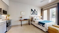Located in the vibrant East Austin neighborhood along Gonzales Street, this efficiently designed studio offers a thoughtfully organized single-floor layout that maximizes every square foot. The open-concept living space seamlessly integrates the sleeping area, living room, and dining zone into one cohesive environment, with polished concrete floors flowing throughout and creating a clean, modern aesthetic.

The kitchen is well-appointed with light wood cabinetry, white subway tile backsplash, stainless steel appliances including a refrigerator, gas range, and built-in microwave, providing full cooking functionality. The sleeping and living areas are bathed in natural light courtesy of large windows and glass doors that open to an outdoor space, framing views of surrounding greenery. A ceiling fan adds comfort to the sleeping area.

A dedicated walk-in closet provides organized storage, while an in-unit laundry adds everyday convenience. The bathroom features a full soaking tub with shower, white subway tile surround, wood-toned cabinetry with overhead storage, and a clean, neutral palette. The overall ambiance of the space is bright and airy, with crisp white walls, consistent flooring, and a modern design language that makes the studio feel open and livable.