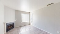 Located at 7434 Auburn Oaks Ct in Citrus Heights, CA, this well-appointed one-bedroom, one-bathroom unit offers a clean, modern aesthetic across a single floor. The living room is light-filled and welcoming, featuring a classic fireplace with a white mantle, light wood-style flooring, neutral gray walls, and a large window fitted with vertical blinds that allow natural light to filter in warmly throughout the day. The kitchen is efficiently laid out with a peninsula breakfast bar that opens to the dining area, granite countertops, cream-toned cabinetry, and a full suite of stainless steel appliances including a refrigerator, range, microwave, and dishwasher. A ceiling fan overhead enhances the comfort of the combined dining space. The bathroom is neatly finished with a full tub-shower combination, granite-topped vanity, and white cabinetry. The bedroom is carpeted for comfort, offering a quiet retreat with a window that brings in natural light. Additional spaces include a closet, laundry area, and utility room, providing practical everyday convenience. The overall interior palette of soft whites and light grays gives the entire unit a clean, cohesive, and move-in-ready feel.