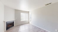 Located at 7434 Auburn Oaks Ct in Citrus Heights, CA, this well-appointed one-bedroom, one-bathroom unit offers a clean, modern aesthetic across a single floor. The living room is light-filled and welcoming, featuring a classic fireplace with a white mantle, light wood-style flooring, neutral gray walls, and a large window fitted with vertical blinds that allow natural light to filter in warmly throughout the day. The kitchen is efficiently laid out with a peninsula breakfast bar that opens to the dining area, granite countertops, cream-toned cabinetry, and a full suite of stainless steel appliances including a refrigerator, range, microwave, and dishwasher. A ceiling fan overhead enhances the comfort of the combined dining space. The bathroom is neatly finished with a full tub-shower combination, granite-topped vanity, and white cabinetry. The bedroom is carpeted for comfort, offering a quiet retreat with a window that brings in natural light. Additional spaces include a closet, laundry area, and utility room, providing practical everyday convenience. The overall interior palette of soft whites and light grays gives the entire unit a clean, cohesive, and move-in-ready feel.
