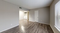 Located at 2050 Old Clinton Rd in Macon, Georgia, this single-story 2-bedroom, 1-bathroom residence offers a well-organized layout designed for comfortable everyday living. The living room features durable wood-look vinyl flooring, neutral gray walls, and a large window that allows natural light to fill the space, creating a bright and open feel. It flows seamlessly into the kitchen and laundry area, enhancing the sense of connectedness throughout the home. The galley-style kitchen is equipped with dark upper cabinetry contrasting white lower cabinets, a double-basin stainless steel sink, a dishwasher, electric range, refrigerator, and a skylight-style ceiling fixture that keeps the space well-lit. An in-unit washer and dryer area is conveniently integrated adjacent to the kitchen. Both bedrooms are carpeted and include ceiling fans with light fixtures and windows with blinds for natural light and ventilation. The spacious primary bedroom features direct access to the bathroom and a closet. The shared bathroom includes a tiled shower-tub combination with chrome fixtures and wood-look flooring. A dedicated closet provides additional storage. Neutral tones and practical finishes create a cohesive, functional living environment throughout.