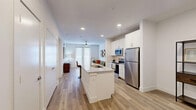 Located at 300 N McDonald St in McKinney, TX, this well-appointed 1-bedroom, 1-bathroom residence offers a thoughtfully designed single-floor layout. The open-concept kitchen and living area form the heart of the home, anchored by a striking granite-topped island with bar seating and an integrated sink — ideal for both meal prep and casual dining. Crisp white shaker cabinetry, a subway tile backsplash, and a full suite of stainless steel appliances, including a refrigerator, range, and microwave, complete the modern kitchen. Light wood-tone flooring flows throughout the main living areas, enhancing the clean, contemporary aesthetic. The living room is bright and welcoming, featuring a ceiling fan and French doors that invite natural light and provide outdoor access. The bedroom offers plush carpeting, a ceiling fan, and a spacious walk-in closet with built-in shelving and hanging rods. The bathroom is generously sized with dual vanities topped in granite, a glass-enclosed shower with white tile surround, a separate soaking tub, and open shelving for added storage. A dedicated laundry area and additional closet space round out the functional layout, making this a comfortable and efficient home.