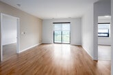 Located at 144 Watson Rd N in Guelph, Ontario, this well-appointed 2-bedroom, 2-bathroom unit offers a clean, contemporary design throughout. Light-toned hardwood flooring flows seamlessly across the entire space, complementing the crisp white walls and creating a bright, cohesive aesthetic.

The open-concept living and kitchen area serves as the heart of the unit. The living room benefits from a large floor-to-ceiling sliding glass door fitted with a roller blind, flooding the space with natural light and providing access to an outdoor area with views of the surrounding Guelph skyline and greenery. The kitchen is efficiently designed with white cabinetry, stainless steel appliances including a range, over-the-range microwave, and dishwasher, along with a double undermount sink, light quartz countertops, and a subtle tile backsplash.

The spacious primary bedroom features its own window with an outdoor view, while the second bedroom is also well-sized and bright. Both bathrooms are finished in a modern style, featuring white vanities with quartz countertops, undermount sinks, brushed nickel hardware, large mirrors, and tiled shower areas. A hallway with a closet provides practical storage. The overall ambiance is clean, modern, and move-in ready.