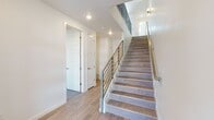 Located at 405 Vin Etienne Dr in El Paso, TX, this contemporary multi-floor home is designed with clean lines and modern finishes across three levels. Wood-look tile flooring flows throughout the main living areas, complementing the bright, neutral color palette that creates a cohesive and welcoming atmosphere.

The kitchen is a standout feature, equipped with rich, dark-toned cabinetry, granite countertops, a large island with an undermount sink, stainless steel appliances including a gas range with a wall-mounted hood, and a French door refrigerator. An adjacent built-in fireplace with white tile surround adds a stylish focal point to the living area, which also features a ceiling fan and natural light from a window.

A staircase with wood-look tile treads and sleek metal railings connects all three floors, with recessed lighting illuminating the stairwell for a polished look. The bedrooms are carpeted for comfort, with ceiling fans and generous walk-in closets offering ample storage.

The primary bathroom is well-appointed with a dual-sink granite vanity, dark wood cabinetry, a large framed mirror, and a tiled walk-in shower with glass enclosure. A half bath on another level echoes the same granite and dark cabinetry design. Throughout, the home balances modern aesthetics with practical, high-quality finishes.