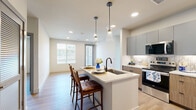 Located at Springs Place in Broomfield, Colorado, this well-appointed residence offers three bedrooms and four bathrooms across a thoughtfully designed single-floor layout. Light wood flooring flows consistently throughout, lending warmth and cohesion to every room.

The modern kitchen is a standout feature, outfitted with two-tone cabinetry combining wood and matte gray finishes, stainless steel appliances including a French door refrigerator and electric range, a tile backsplash, white quartz countertops, and a central island with an undermount sink and pendant lighting overhead.

The bedrooms are bright and well-proportioned, with clean white walls, natural light from sizable windows with blinds, and ample closet space. The primary bedroom includes a dedicated closet and an en-suite bathroom. The bathrooms are finished with elegant large-format stone-look tile, including a soaking tub with brushed bronze hardware in one bath and a dual-sink vanity with a bold blue cabinet and modern sconce lighting in another.

A dedicated laundry room houses a full-sized Whirlpool front-load washer and dryer with overhead shelving for added storage. The overall aesthetic is clean, contemporary, and move-in ready, offering functional living spaces with modern finishes throughout.