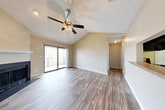 Located in Chattanooga, TN, this single-floor residence offers a thoughtfully designed layout with a blend of comfort and functionality. The open living area immediately impresses with soaring vaulted ceilings, a ceiling fan with light fixture, and a textured ceiling that adds character. Durable wood-look plank flooring runs throughout the main living spaces, providing a warm and cohesive aesthetic. A classic fireplace with a white mantel serves as a focal point, while sliding glass doors flood the room with natural light and lead directly to an outdoor deck, perfect for enjoying the surrounding greenery.

The kitchen is efficiently arranged with dark cabinetry, granite-look countertops, and black stainless appliances including a gas range, built-in microwave, and refrigerator. Wood-look flooring continues here, maintaining a consistent feel throughout.

The bedrooms feature plush carpeting and neutral wall tones, creating a calm and restful atmosphere. The primary bedroom includes a walk-in closet with shelving and direct access to a private bathroom. The bathroom is outfitted with a full tub-shower combination surrounded by classic white tile.

Overall, this home presents a clean, neutral palette with practical finishes and comfortable living spaces throughout.