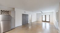 Located at 8700 Seeing Trail Rd in Wake Forest, NC, this 2-bedroom, 2-bathroom single-floor residence offers a clean, modern aesthetic defined by polished concrete floors that flow seamlessly throughout the entire space. The open-concept living, dining, and kitchen area forms the heart of the home, filled with natural light and anchored by stylish track lighting. French doors in the living area provide a welcoming entry point and connect the interior to the outside. A built-in shelving nook adds a practical yet decorative touch near the main living zone. The kitchen is well-appointed with gray shaker-style cabinetry, granite countertops, a stainless steel farmhouse sink, a full suite of stainless steel appliances, a classic white subway tile backsplash, and a built-in wine rack — combining function with refined detail. Both bedrooms are comfortably sized, featuring ceiling fans and crisp white walls, with the primary bedroom offering generous proportions and direct access to closets. The bathrooms are finished with granite vanity tops, LED-lit mirrors, gray cabinetry, and glass-enclosed showers. A dedicated laundry area and four closets round out the practical layout of this thoughtfully designed residence.