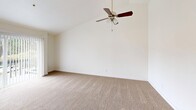 Located at 30823 18th Ave S in Federal Way, WA, this one-bedroom, one-bathroom residence offers a thoughtfully utilized single-floor layout with a clean, neutral aesthetic throughout. The living room is a standout space, featuring vaulted ceilings that lend a sense of openness and volume, plush wall-to-wall carpeting, and a ceiling fan. Sliding glass doors fitted with vertical blinds open directly onto a private balcony, bringing in natural light and views of the surrounding neighborhood. The kitchen is well-appointed with crisp white shaker-style cabinetry, light stone-look countertops, stainless steel appliances including a refrigerator and range with overhead ventilation, and recessed lighting — offering a functional and modern cooking space. The bedroom is a comfortable size, carpeted like the living areas, and includes a large window with blinds that allows natural light in while providing privacy. A baseboard heating system runs along the wall. The full bathroom features a combined tub and shower with clean white surrounds. Four closets are distributed throughout the unit, providing generous storage. A hallway connects the main areas efficiently, completing this well-organized and move-in ready residence.